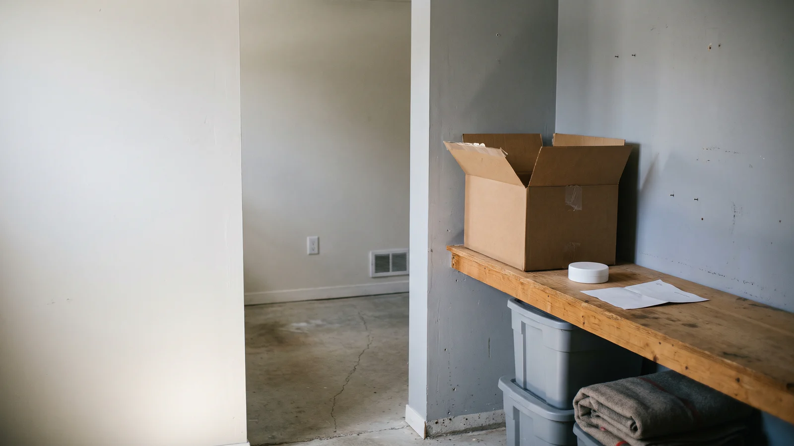A radon test kit and detector on a shelf in a basement.